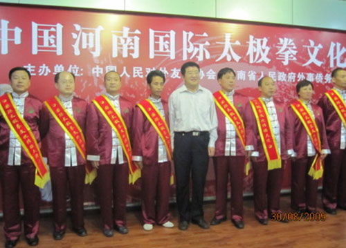 河南省对外友好协会秘书长赵青山（中）与身披“国际太极拳文化传播大使绶带”的部分拳师们在一起